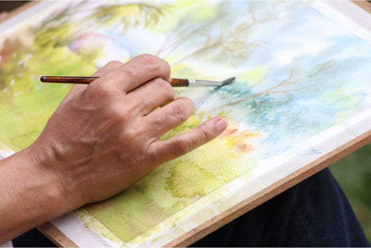 Man painting green scenery outdoors
