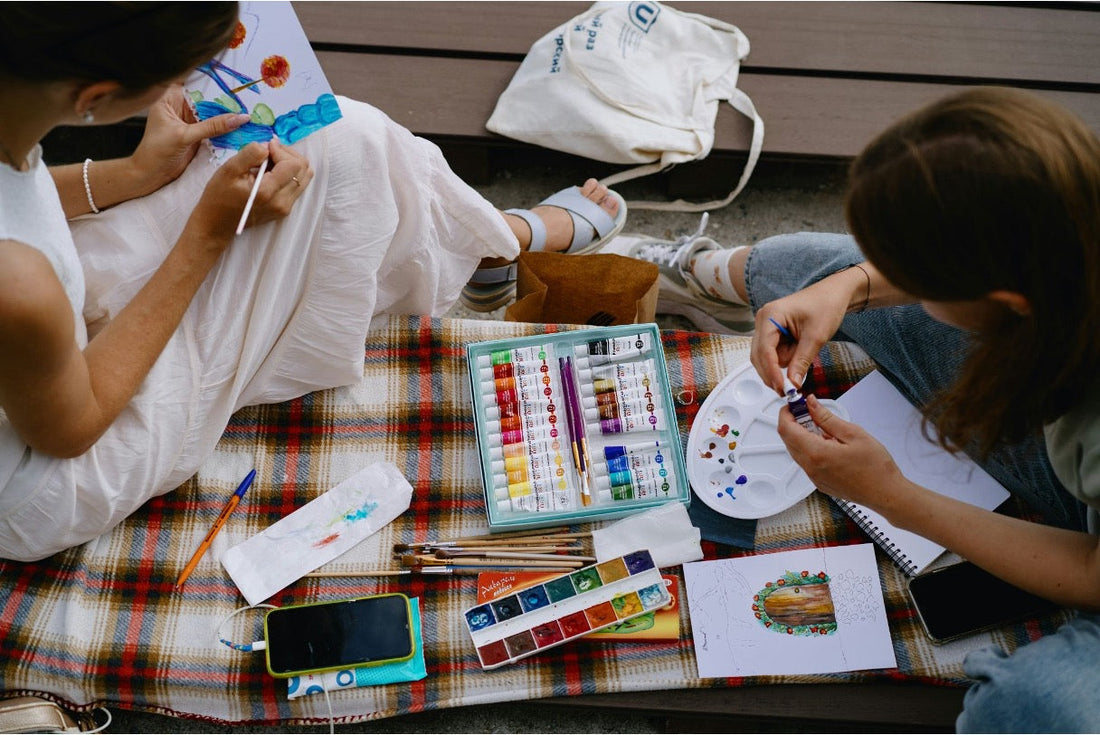 Two teens painting outdoors
