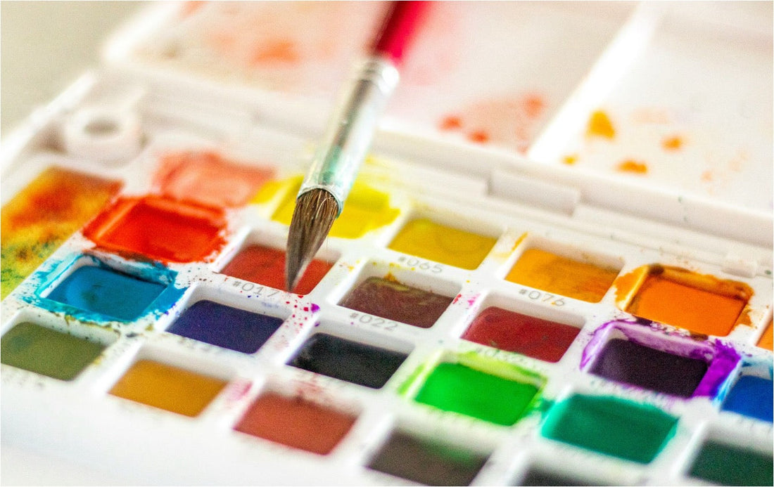 Watercolor tray and a paintbrush