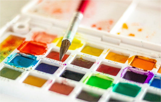 Watercolor tray and a paintbrush