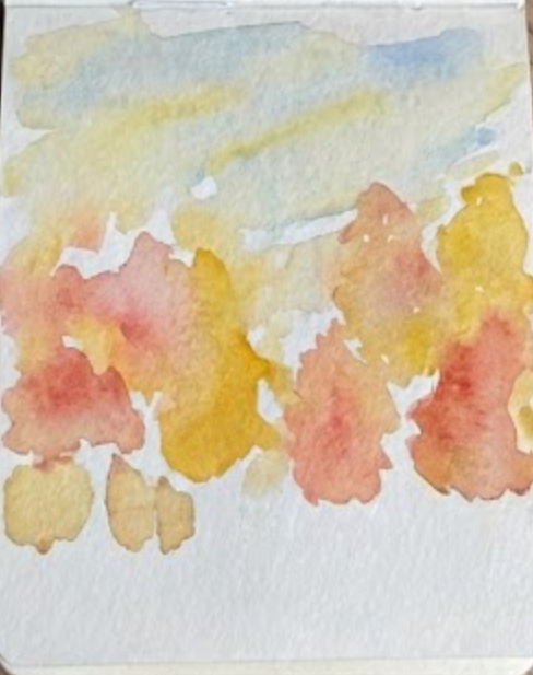 Initial wet-on-wet washes of yellow, orange, and soft red watercolor forming the base foliage and sky for an autumn watercolor painting.