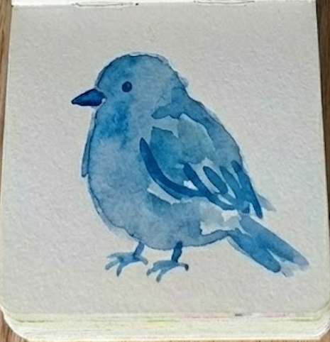 Completed loose bluebird watercolor painting showing final dark eye, beak, and feet details in a sketchbook.