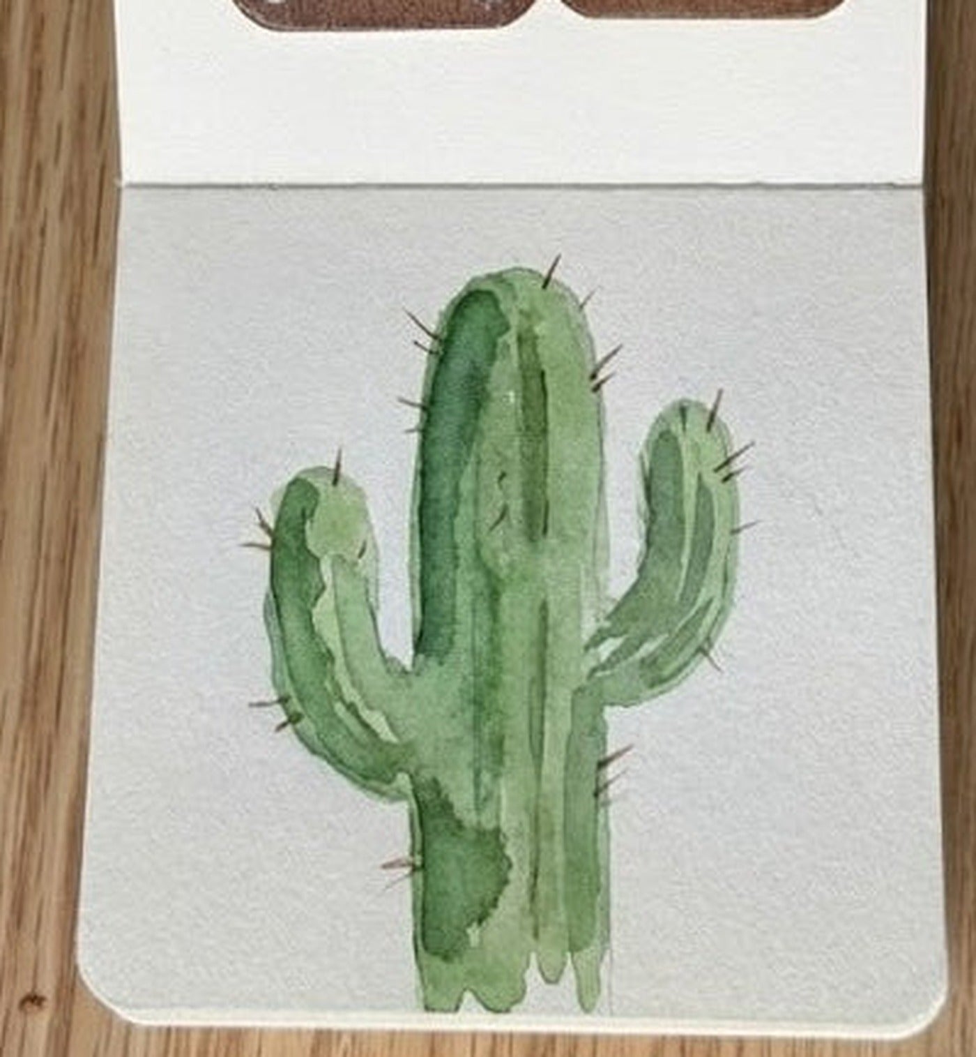 Watercolor cactus painting on cream paper