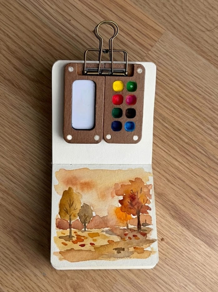 Small fall watercolor painting on a wooden surface
