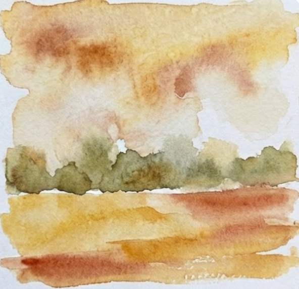 Step 2 of a fall watercolor painting adding a soft, blurred horizon line of distant bushes and a warm foreground wash.