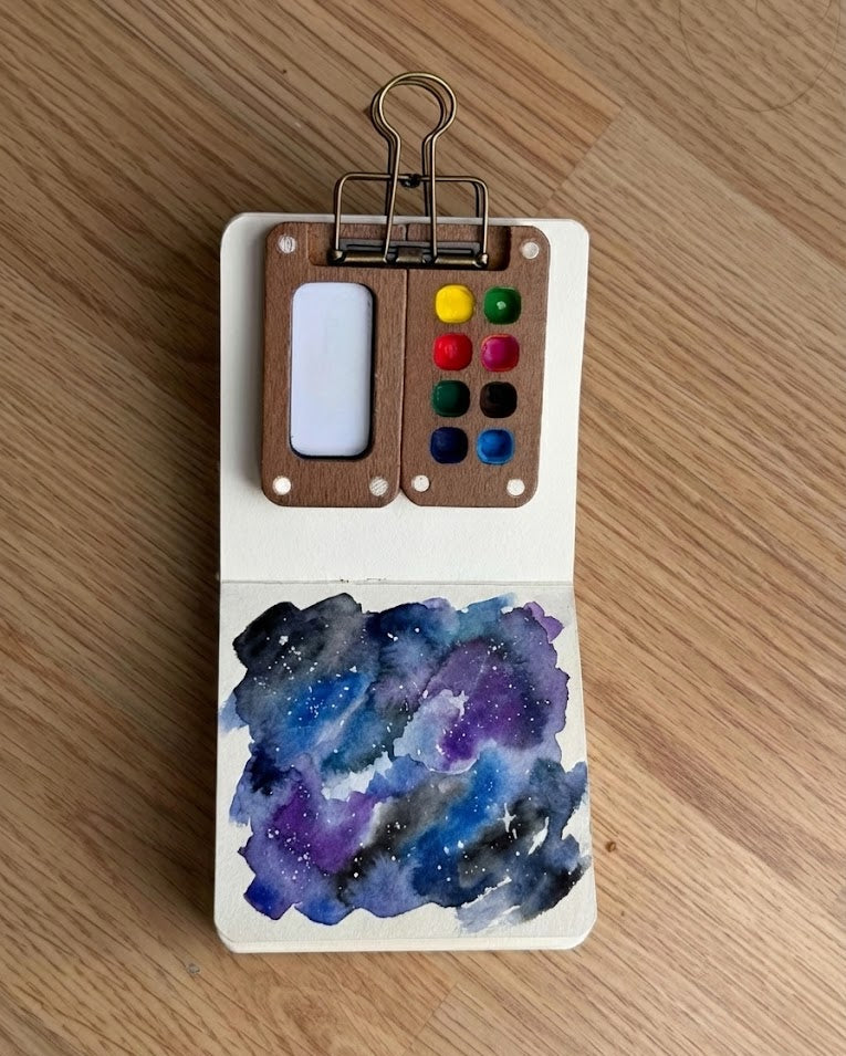 Tobio’s Kits galaxy watercolor painting, featuring dark washes and stars in a sketchbook.