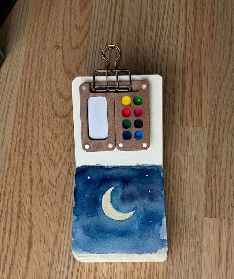 Small notebook with a moon and star design on a wooden surface
