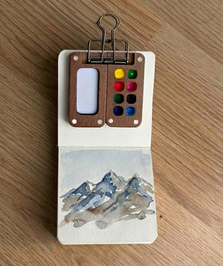 Watercolor painting of a mountain with a blue background