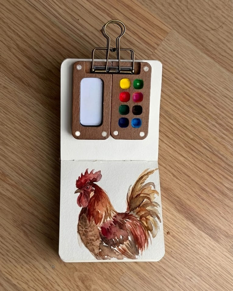 Tobio’s Kits rooster watercolor painting, painted in a small watercolor sketchbook with soft washes and simple details.