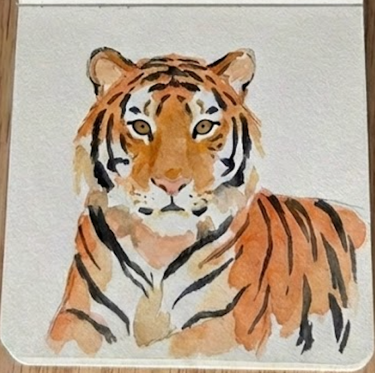 Step 4: The final expressive tiger watercolor painting featuring varied black stripes and soulful eyes next to a wooden mini palette.