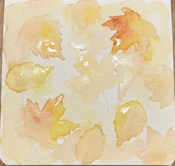 A light, wet-on-wet wash of yellow and pale orange watercolor is applied within the sketched leaf shapes, creating a base for a loose watercolor painting of autumn leaves.