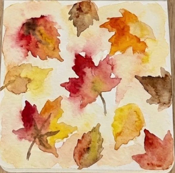Deeper red, orange, and brown watercolor pigments are 'charged' or dropped into the wet leaf base, allowing colors to bleed and blend naturally, in step three of a watercolor painting of autumn leaves.