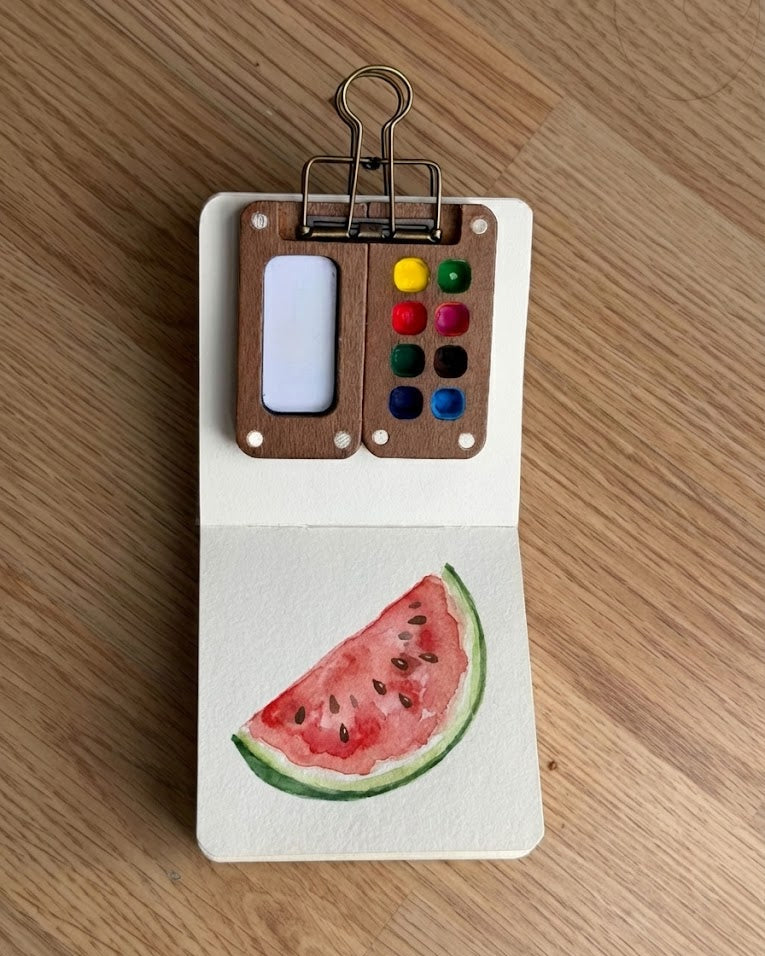 Tobio’s Kits watermelon watercolor painting, painted in a small watercolor sketchbook with bright colors.